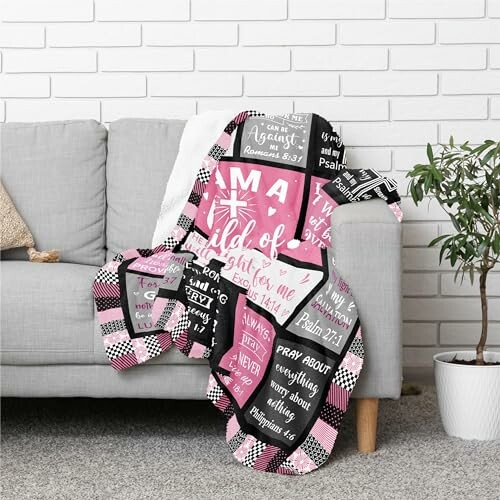 Christian-themed quilt with Bible verses on a sofa.